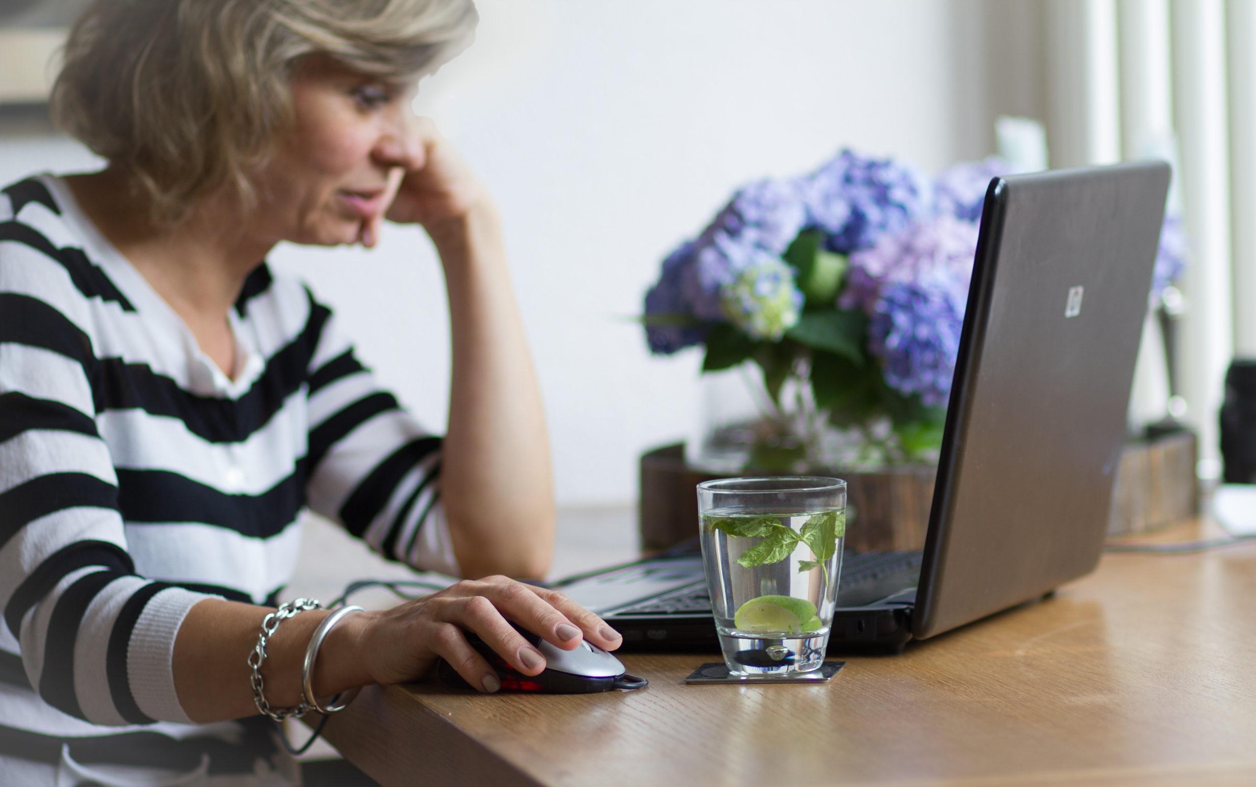 Attractive middle-aged woman looking at the monitor